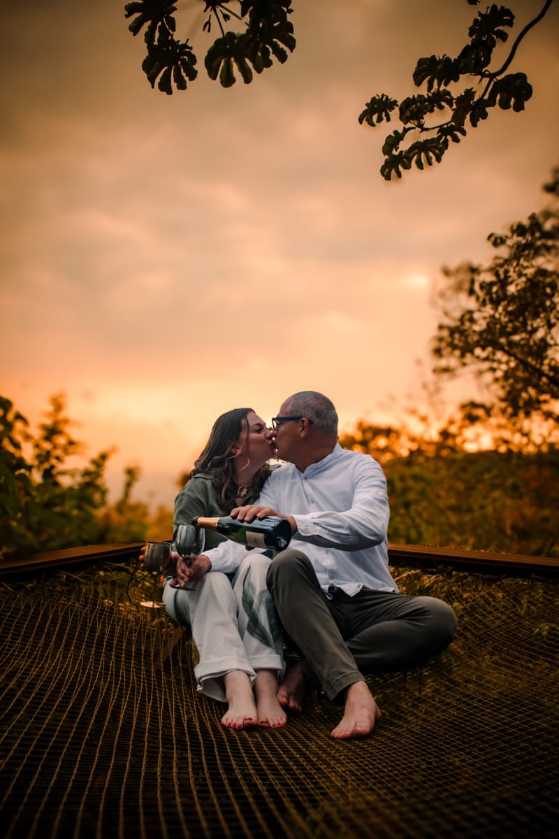 Pareja brindando al atardecer en el domo