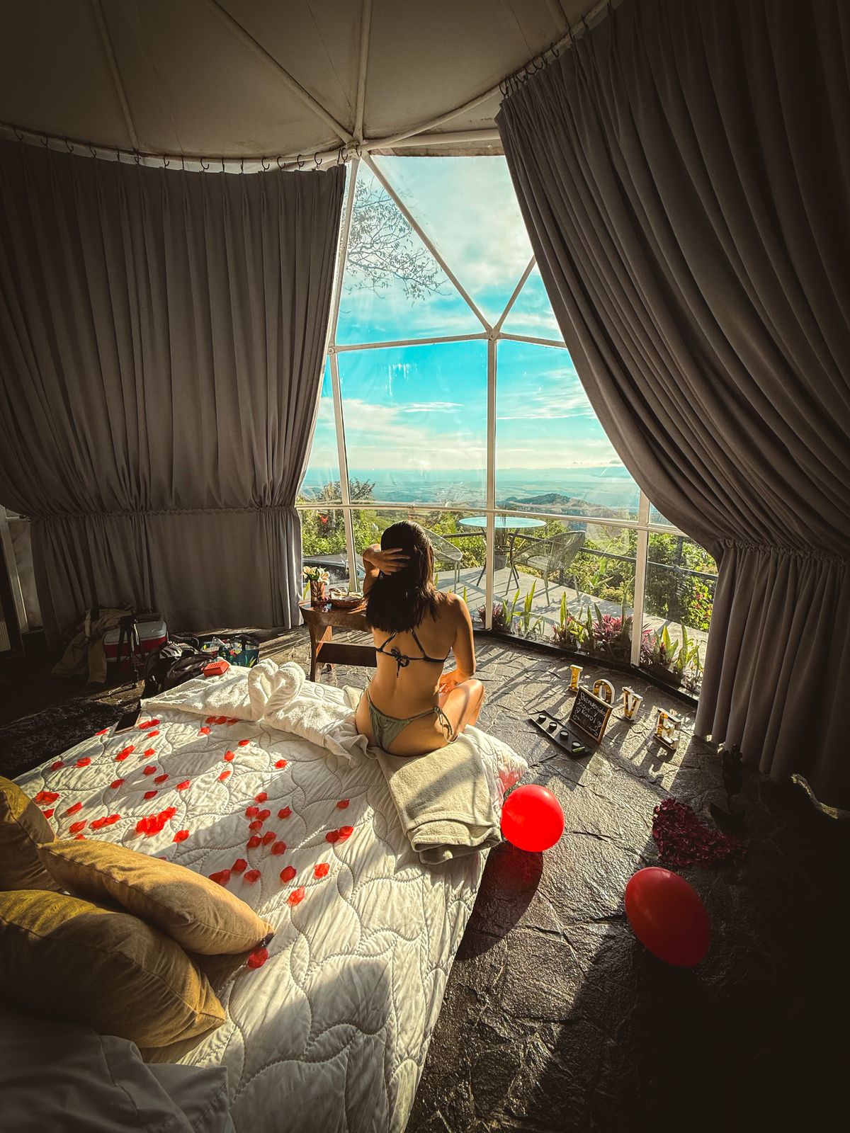 Pareja romántica junto a la ventana del domo con vista a la selva